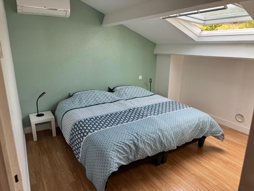 a bedroom with a bed in a room with a skylight at La petite Varenne 28 in La Chapelle-du-Noyer