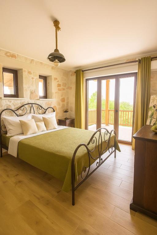 a bedroom with a bed with a green bedspread at La Casa Del Sole in Agios Leon