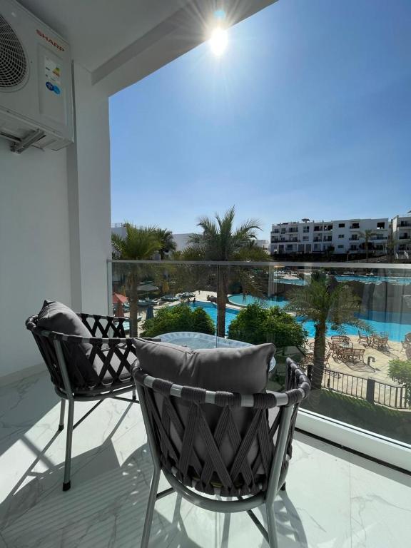 a balcony with two chairs and a view of a pool at Studio102 in Naama bay in Sharm El Sheikh