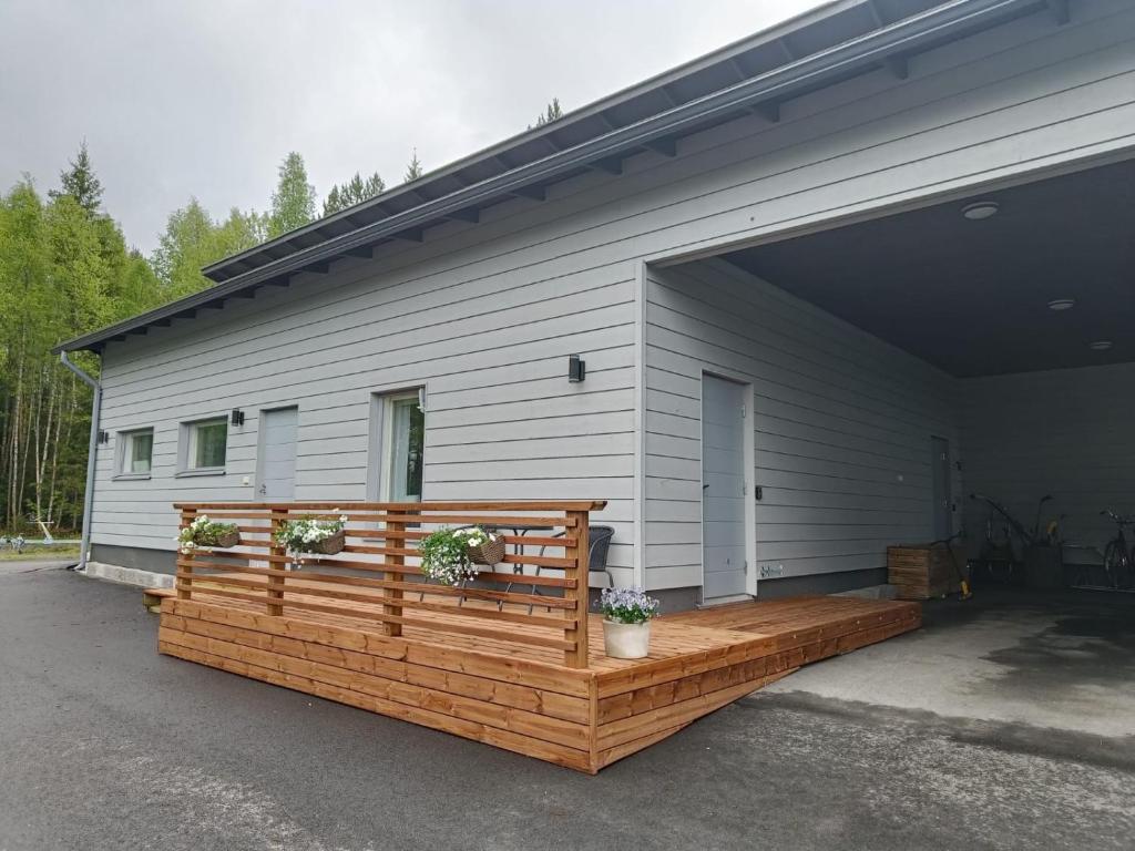 a house with a wooden deck with two potted plants at Kontion keidas Maaseudulla Varattavissa myös Takkatupa ja Sauna in Oulu
