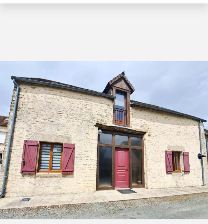 - un bâtiment en briques avec des portes et des fenêtres rouges dans l'établissement ancienne grange, à Arçonnay