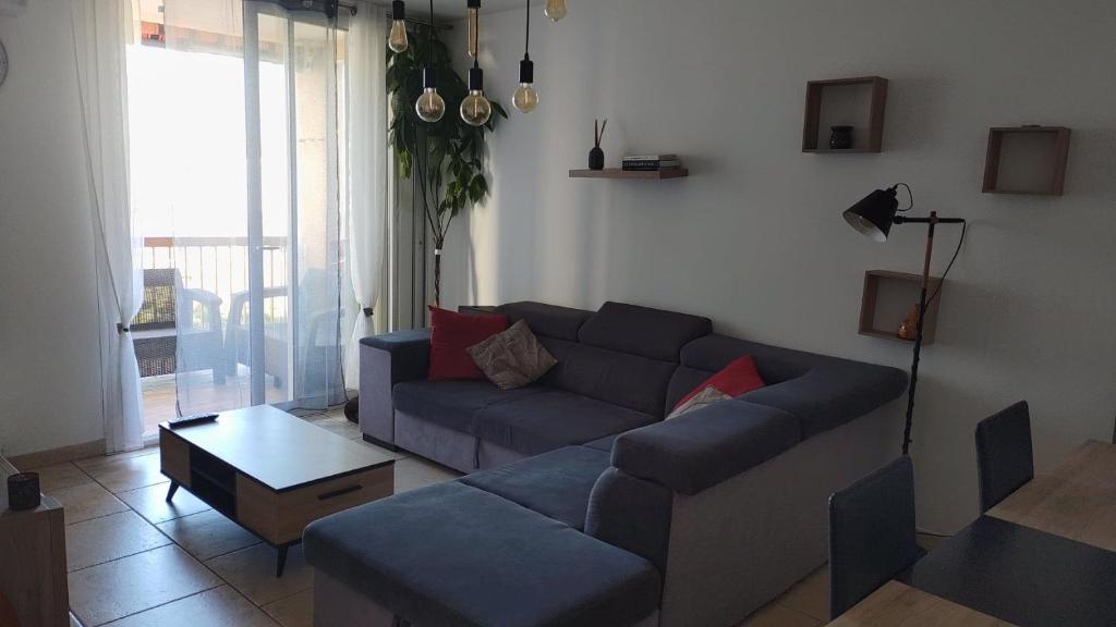 un salon avec un canapé bleu et une table dans l'établissement appartement le cézanne, à Toulon