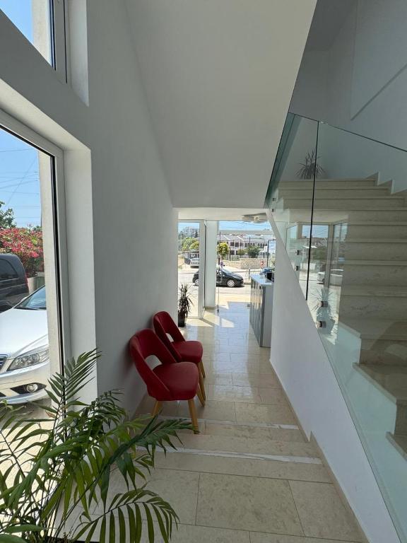 a red chair sitting on a staircase in a house at Otto Hotel in Ksamil