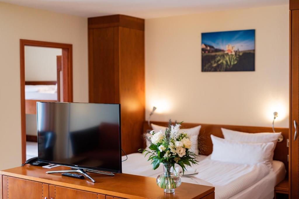 a hotel room with a television and a bed at Hotel Atlantic Juist in Juist