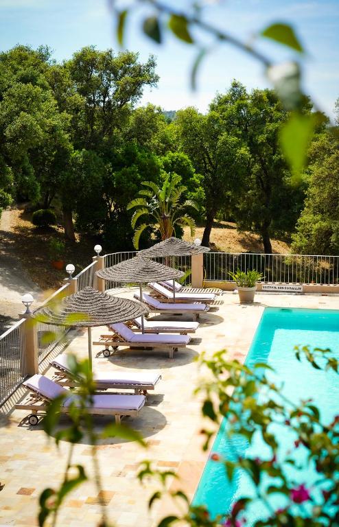 une rangée de chaises longues à côté d'une piscine dans l'établissement Villa Nais B&B, à Bormes-les-Mimosas