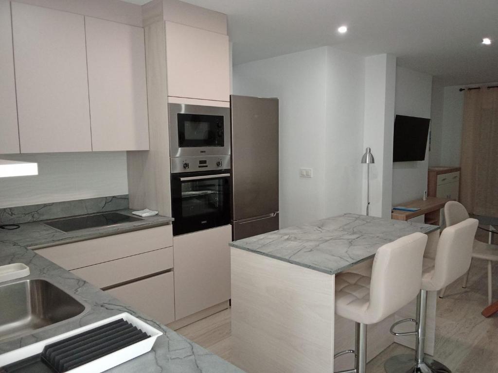 eine Küche mit weißen Schränken und einer Arbeitsplatte in der Unterkunft San Pedro del Pinatar Casa Sweeney in Lo Pagán