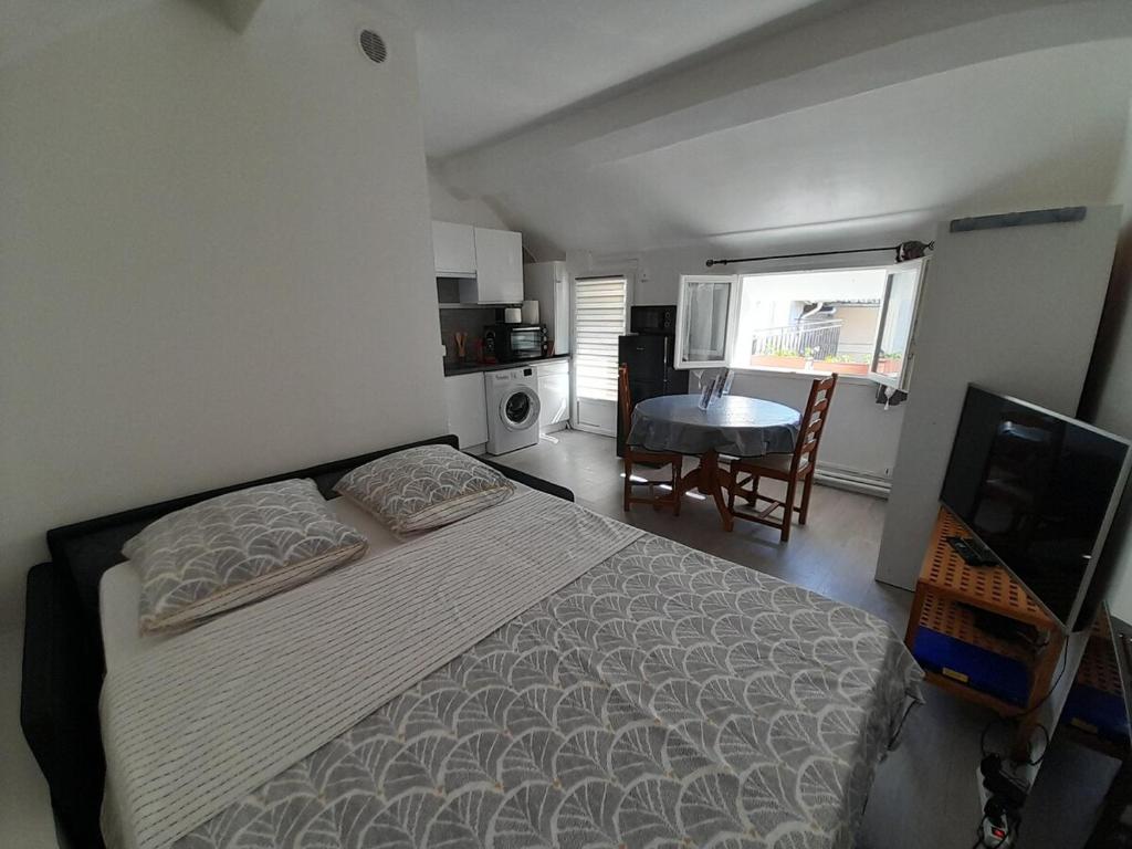 une chambre avec un lit, une table et une télévision dans l'établissement Charmant studio a Bois le Roi avec parking prive, à Bois-le-Roi