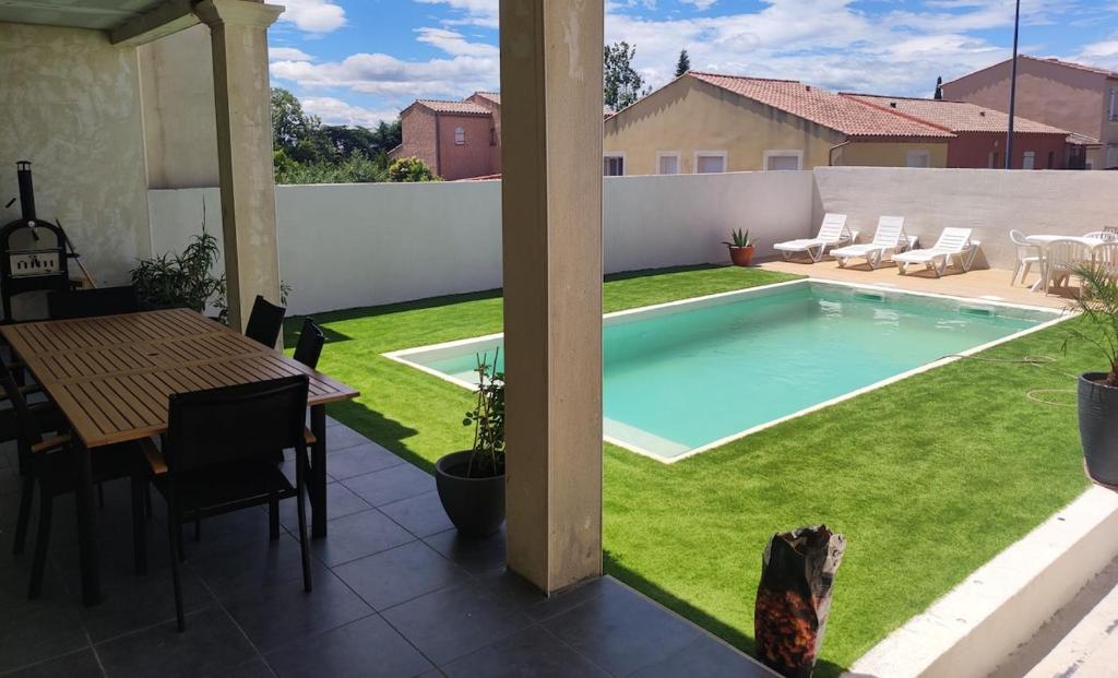 une cour avec une piscine, une table et des chaises dans l'établissement House in Gard, à Saint-Gervasy