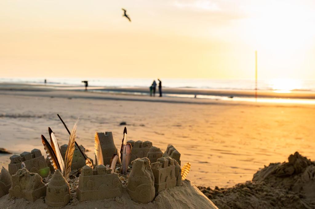 a sand castle on the beach with people in the background at Hotel Atlantic Juist in Juist