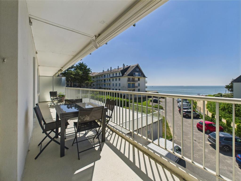 un balcon avec une table et des chaises et l'océan dans l'établissement Vue mer - Appart pour 4 - Grand balcon, à Pornichet