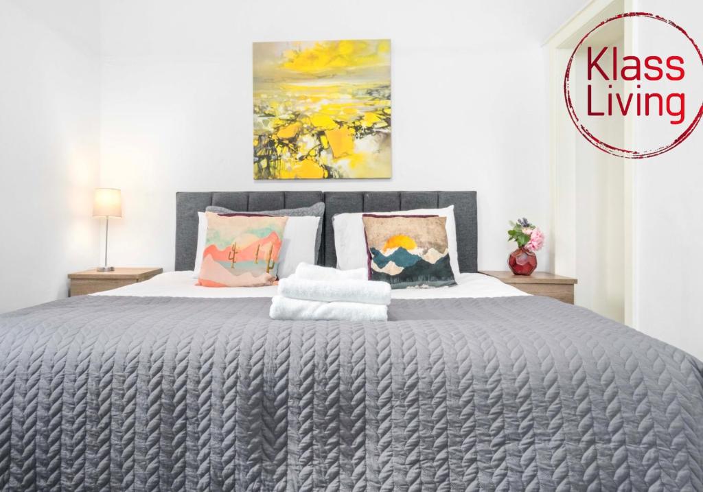 a bedroom with a large gray bed with pillows at Broomfield Apartment by Klass Living Airdrie in Airdrie
