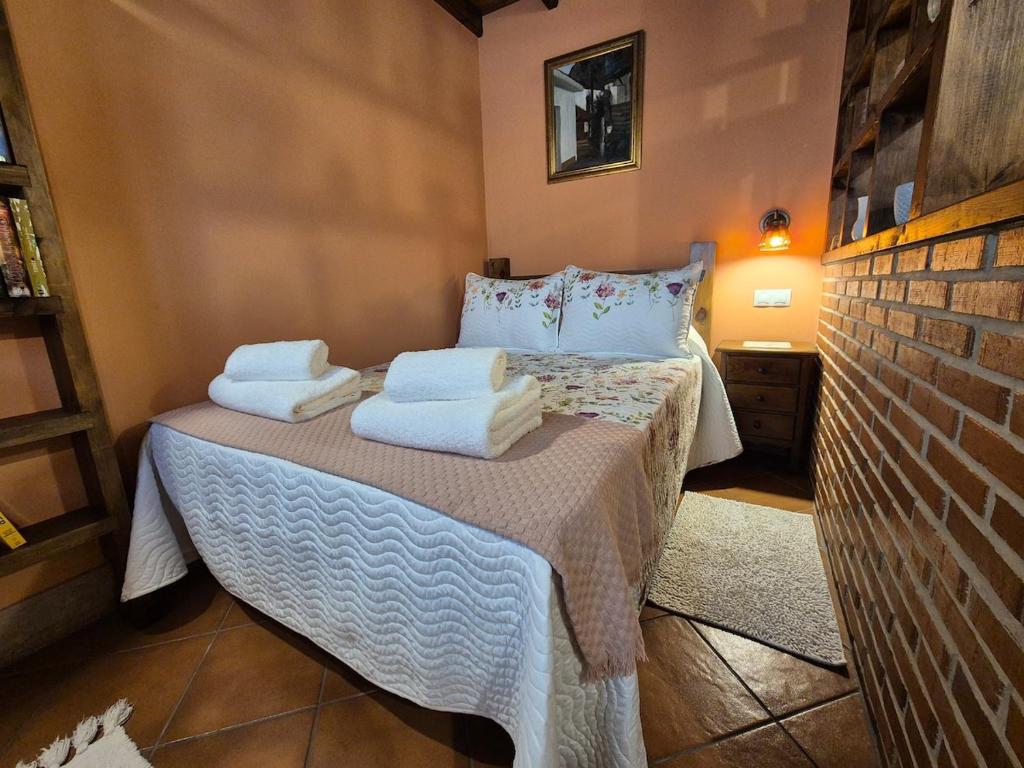 a bedroom with a bed with towels on it at 211A La Chalana Bonito Estudio en Tazones in Tazones