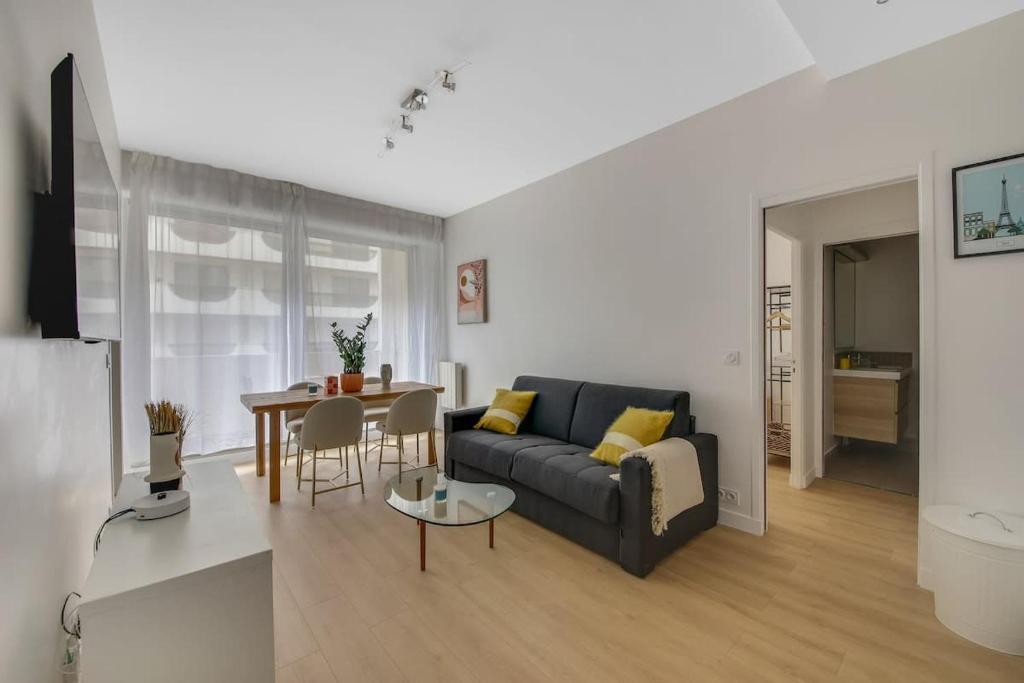 un salon avec un canapé et une table dans l'établissement Charming apartment near Eiffel Tower 2BR II, à Paris