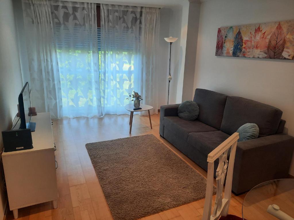 a living room with a couch and a television at NextGarden in Padrón
