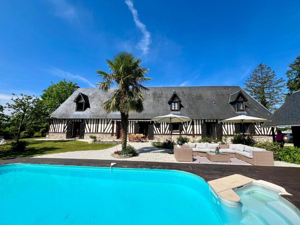 une maison avec une piscine devant dans l'établissement Maison de campagne en Normandie, à Saint-Martin-Saint-Firmin