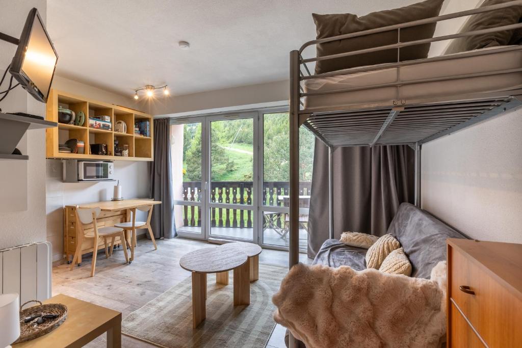 - un salon avec des lits superposés et une table dans l'établissement Le Mont Louis - Accès direct remontées mécaniques, aux Angles