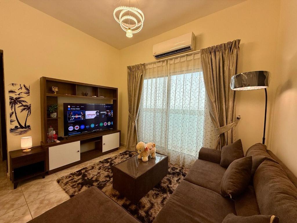 Μια τηλεόραση ή/και κέντρο ψυχαγωγίας στο Cozy Sea View Apartment in the heart of Ajman