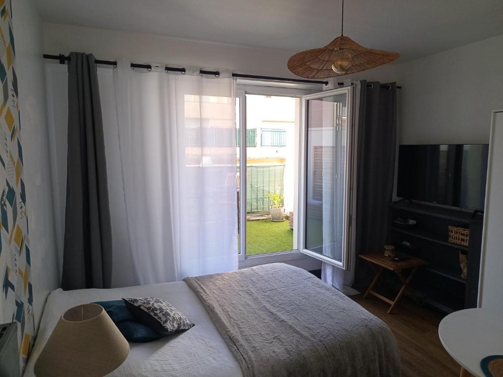 une chambre avec un lit et une grande fenêtre dans l'établissement Studio tout confort avec terrasse, à Pau