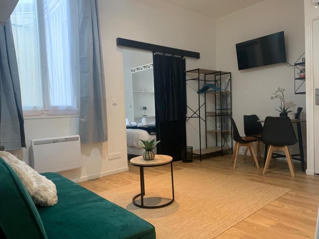 un salon avec un canapé vert et une table dans l'établissement Quiet and lovely Paris Center, à Paris