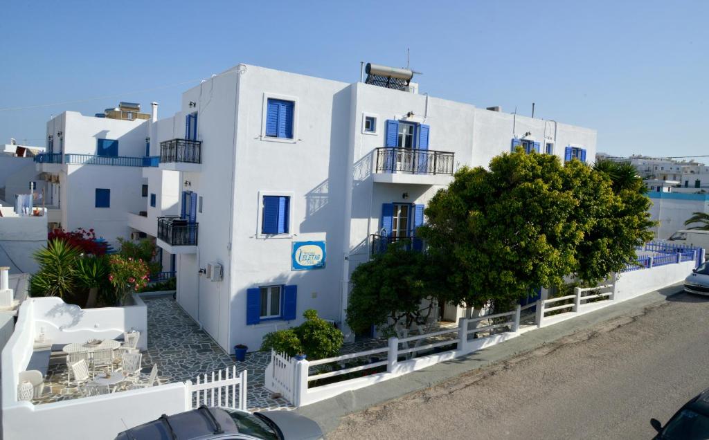 a view of a white building with blue windows at Veletas Rooms in Adamantas