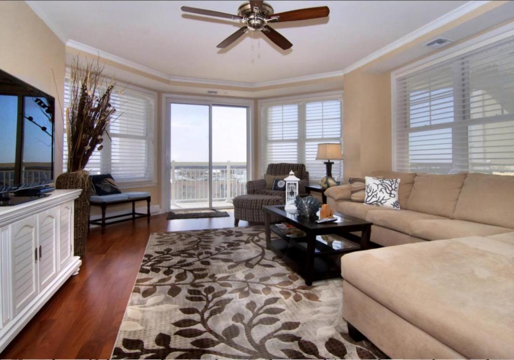 a living room with a couch and a ceiling fan at Residence 810 At The Grand in Wildwood