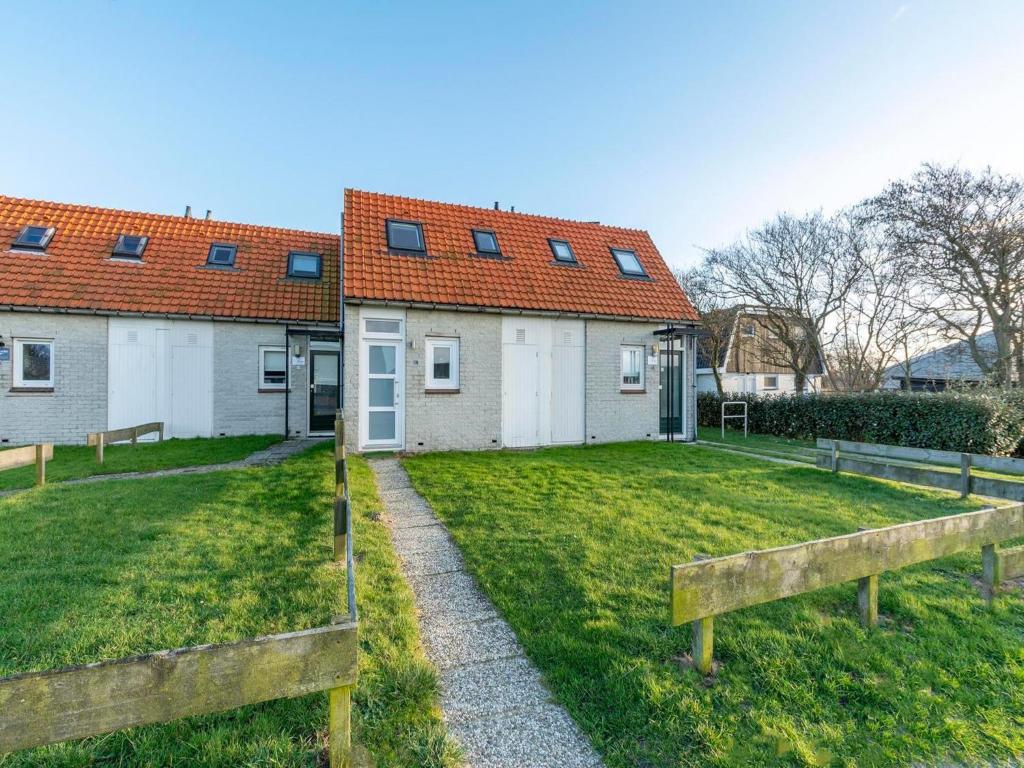 une maison avec une cour devant dans l'établissement Holiday Home in Callantsoog near Beach, à Callantsoog