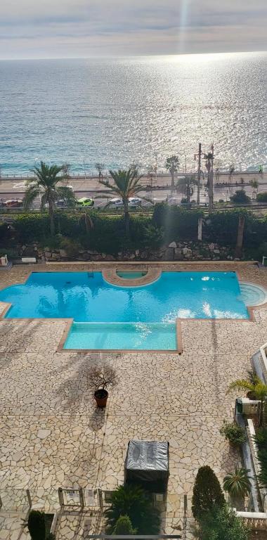 une vue aérienne de deux piscines à côté de l'océan dans l'établissement Pierre Vacances Appt 748 VUE MER, à Cannes