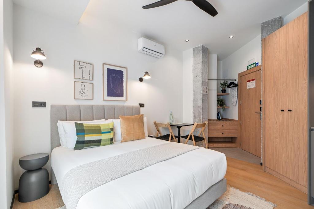 a bedroom with a large bed and a table at Dobo Madrid Moncayo in Madrid