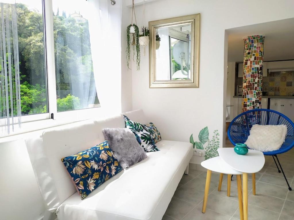 - un salon avec un canapé blanc et une fenêtre dans l'établissement Cascade Esacapade Duplex, à Nice