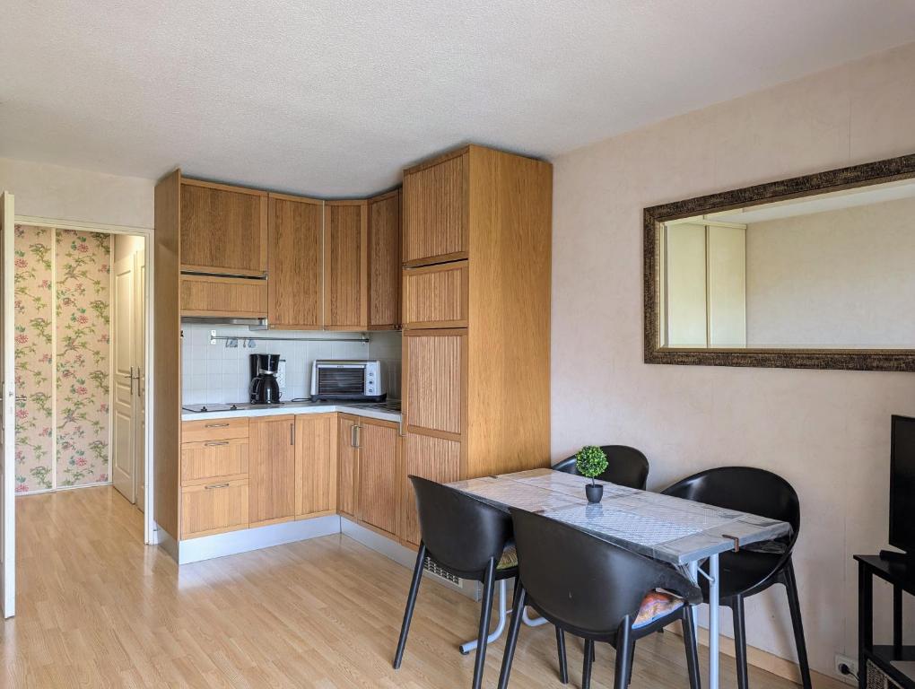 une cuisine et une salle à manger avec une table et des chaises dans l'établissement Fréjus plage T1 bis climatisé- 4 Pers - balcon- côte d'Azur, à Fréjus