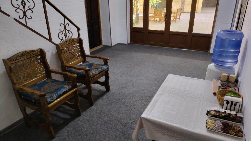 a room with two chairs and a table and a door at Samar Oasis in Bukhara