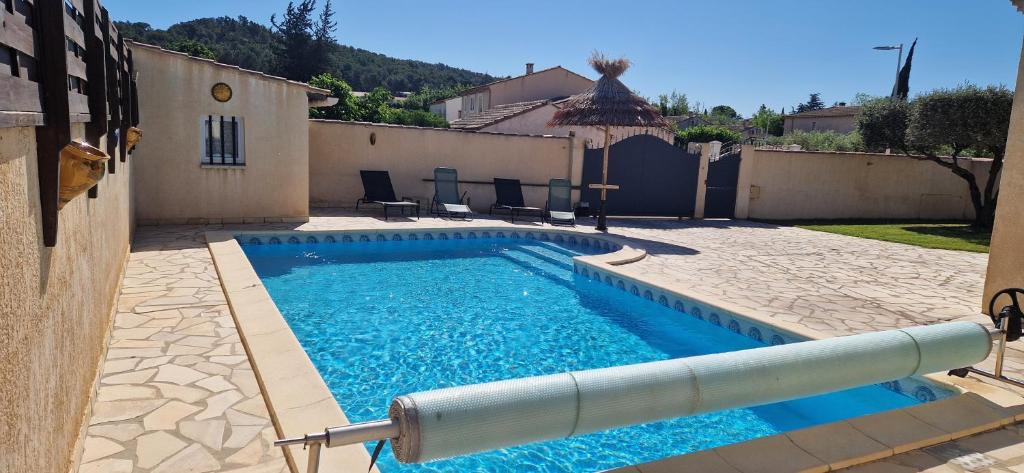 une piscine avec de l'eau bleue dans une cour dans l'établissement En Occitanie - Belle villa familiale avec piscine privée - Idéale avec enfants, à Beaucaire