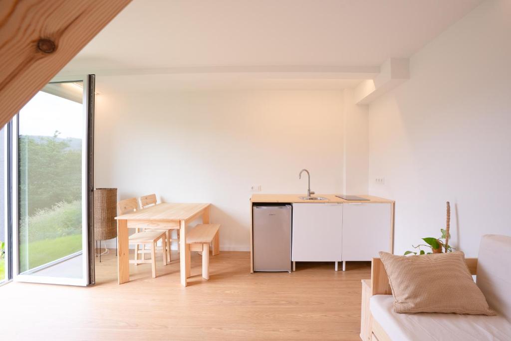 a living room with a kitchen and a table at UMI surf yoga house Doniños beach in Ferrol