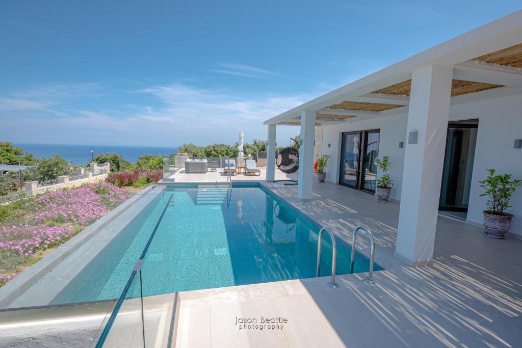 a villa with a swimming pool and the ocean at Villa Lilianna Private Luxury Villa in Marathias