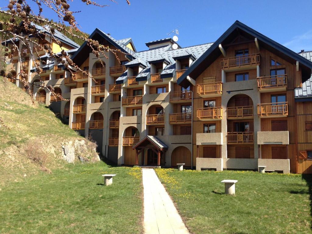 a large apartment building with a pathway in front of it at Le Bouquetin - Immeuble Le Pluton in Les Deux Alpes