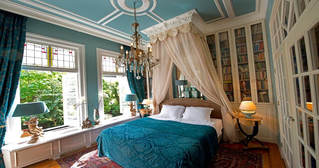 a bedroom with a bed and a chandelier at Breitner House in Amsterdam