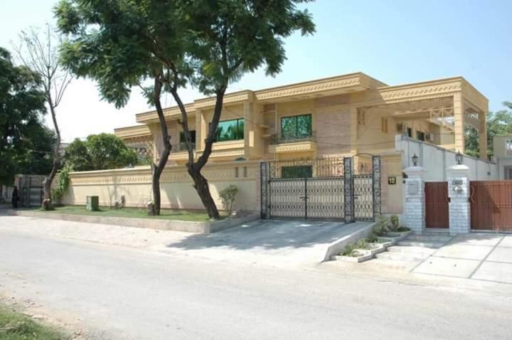 ein Haus mit einem Tor und einem Baum davor in der Unterkunft Royal Crown in Islamabad