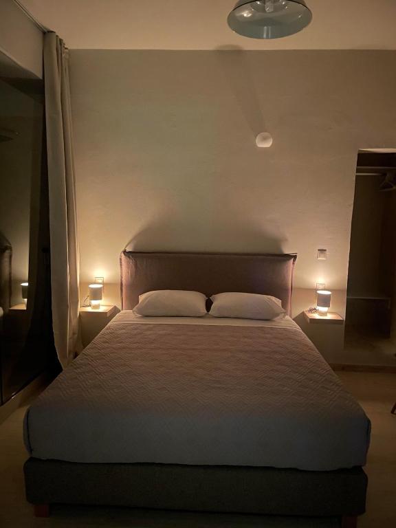 a bedroom with a bed with two pillows and two lights at Villa Sylvia in Matala
