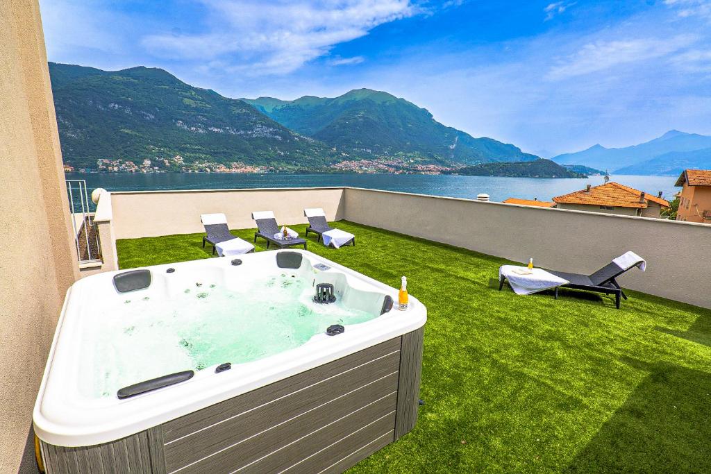 a hot tub on a lawn with a view of the water at Spa Stella Lario in Lezzeno