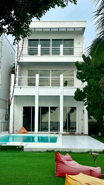 a large white building with a swimming pool in front of it at Hi Yang Seaview Villa in North Pattaya