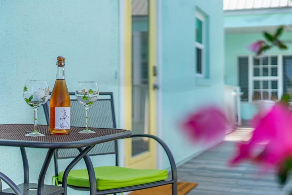 a bottle of wine sitting on a table with two glasses at Stay ON Flagler Avenue! Charming Condo with Full Kitchen, Parking and Courtyard! in Chicken Island