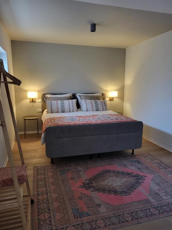 a bedroom with a bed with two pillows and a rug at B&B Ut Zuuje in Valkenburg