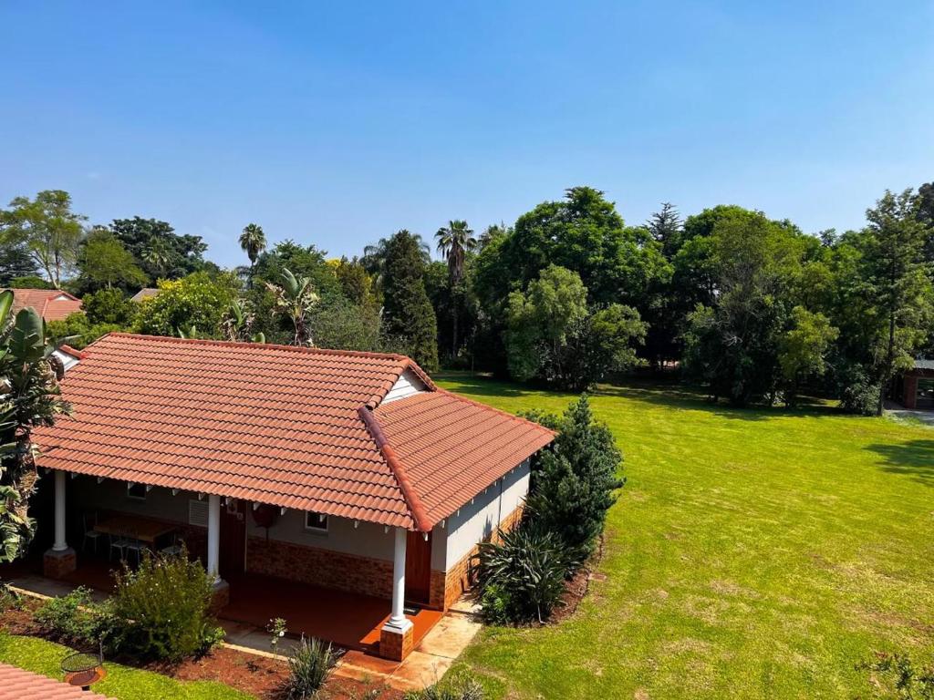 a house with an orange roof and a yard at Platinum Airport Lodge & Guesthouse in Pretoria