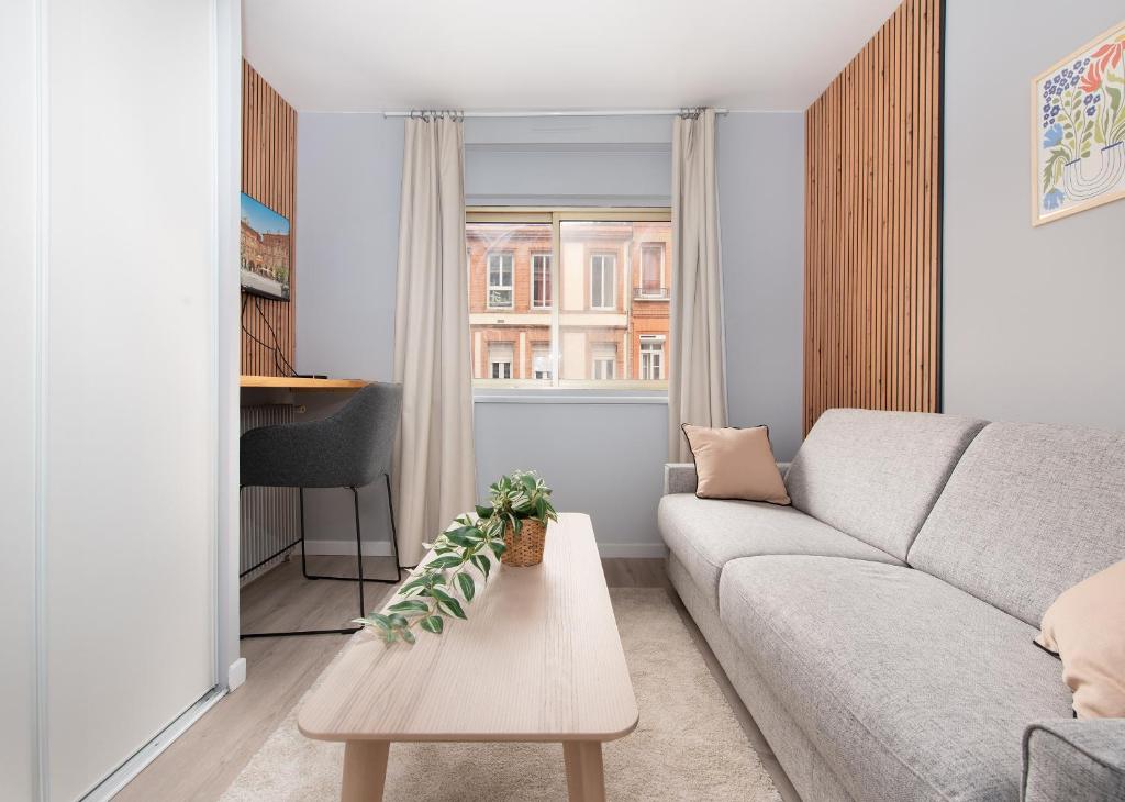 un salon avec un canapé et une table dans l'établissement Studio Raymond IV - élégance et confort, à Toulouse