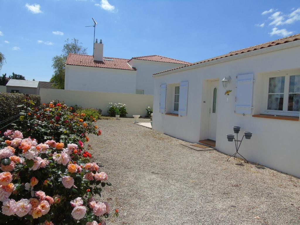 a driveway of a house with flowers in front of it at Pré-Rochet in Saint-Jean-de-Monts