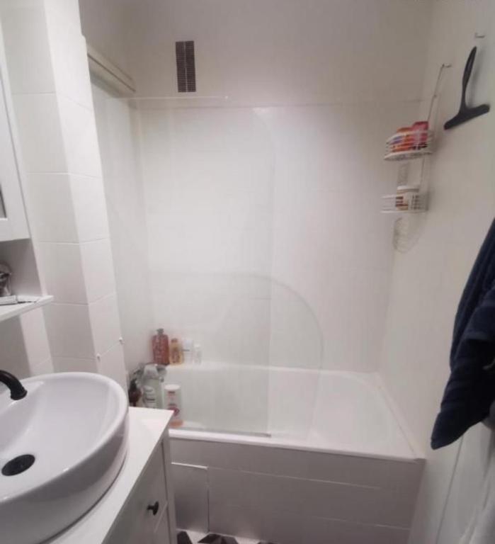 une salle de bain blanche avec un lavabo et une baignoire dans l'établissement Paris's appartement, à Gennevilliers