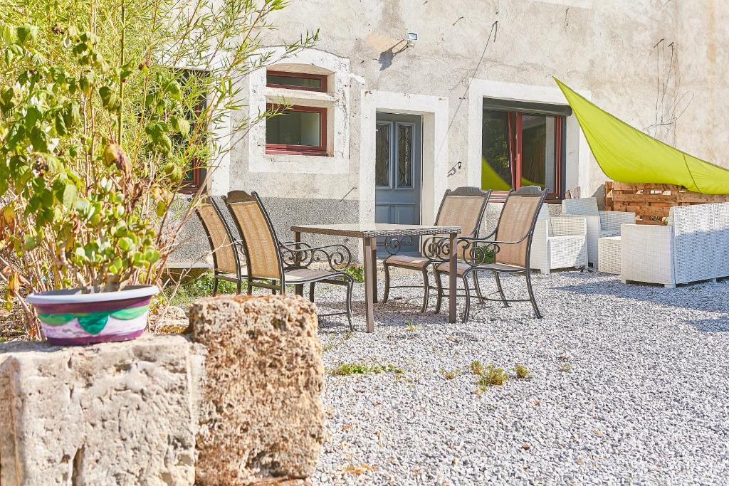 - un ensemble de chaises et d'une table sur la terrasse dans l'établissement Joyone,appartement rénové dans maison vigneronne de 1682 avec terrasse, à Mouthier-Haute-Pierre