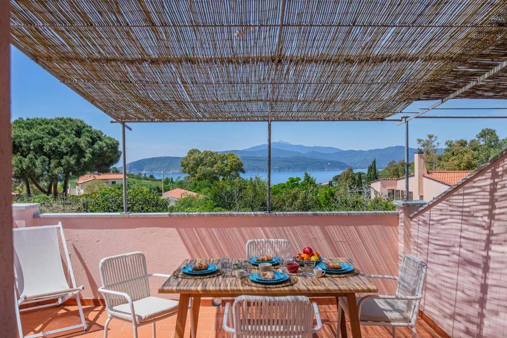 a table on the balcony with a view of the water at Villa del sole 4 in Capoliveri