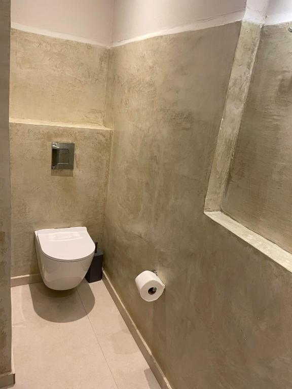 a bathroom with a toilet and a roll of toilet paper at Villa Sylvia in Matala