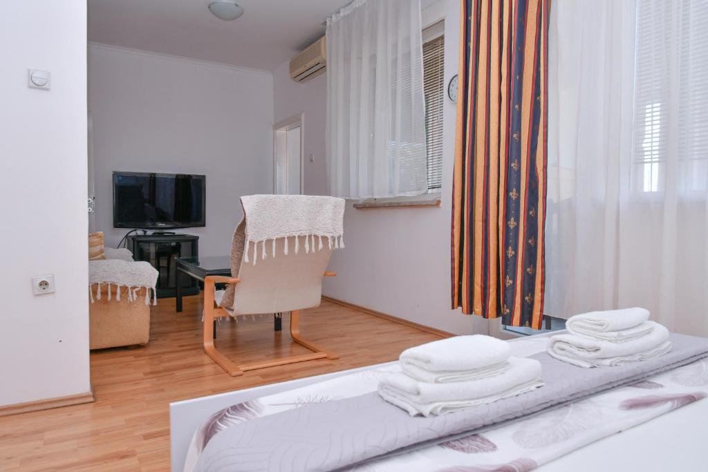 a room with a bed and a chair and a television at DIANANINA the Flat in Gevgelija